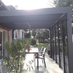 Pergola bioclimatique alu anthracite 10,80m² toit avec lames ovales alu + 5 panneaux moucharabieh + 1 rideau gris – HABRITA
