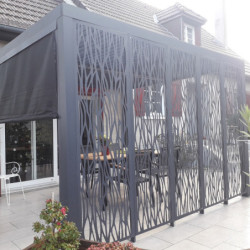 Pergola bioclimatique alu anthracite 10,80m² toit avec lames ovales alu + 5 panneaux moucharabieh + 1 rideau gris – HABRITA