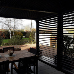 Pergola bioclimatique aluminium anthracite 10,80m² toit avec lames ovales aluminium + ventelles latérales pour côté 3m – HABRITA